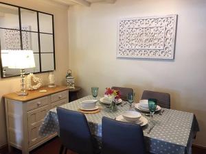 a dining room with a table with blue chairs and a tableablish at Islas Cottage in Ystradgynlais