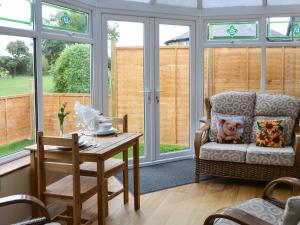 a living room with a table and a chair at The Gin Gan Cottage in Ryal