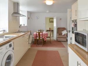 une cuisine avec un lave-linge et une salle à manger dans l'établissement Sisial Y Gwynt, à Llanferres