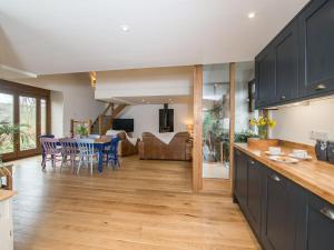 a kitchen and living room with a table and chairs at Harewood Barn in Brompton Regis