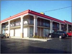 a building with a car parked in a parking lot at Super 8 by Wyndham Oklahoma Fairgrounds in Oklahoma City