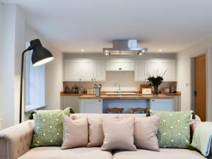 a living room with a couch and a kitchen at The Old Stables 2 - Uk35616 in West Winterslow