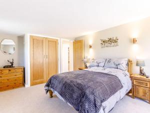 a bedroom with a bed and a dresser and a mirror at The Old Dairy in Shipton under Wychwood