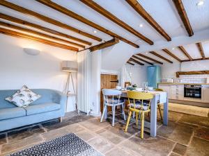 a living room with a blue couch and a table at Box Tree Cottage in Blakeney