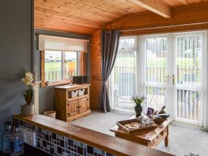 a living room with a table and a large window at Cairnswood in Swarland