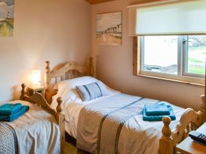 a bedroom with two twin beds and a window at Cairnswood in Swarland