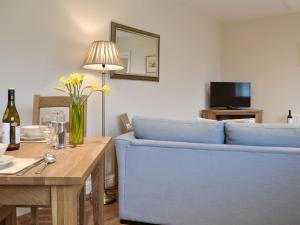 a living room with a blue couch and a table at Croft Cottage 3 - Uk10589 in Stillington