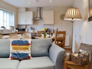 a living room with a couch and a kitchen at Croft Cottage 3 - Uk10589 in Stillington