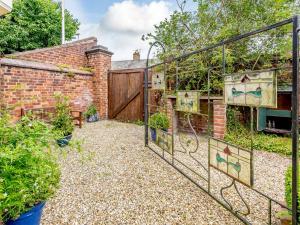 a garden with a gate and a brick building at Top Studio-uk35143 in Lincoln