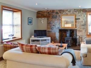 a living room with a couch and a fireplace at East Lewiston in Drumnadrochit