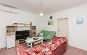 een woonkamer met een bank en een tv bij Nice Apartment In Utjeha With Kitchen in Utjeha