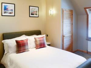a bedroom with a white bed with two pillows at East Lewiston in Drumnadrochit