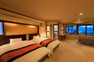 2 łóżka w pokoju hotelowym z oknami w obiekcie Hayamakan w mieście Kaminoyama