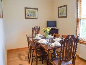 a dining room with a table and chairs and a television at Beech Walk in Crail