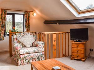 sala de estar con silla y TV en Swallows Folly-uk38278, en Cloughton