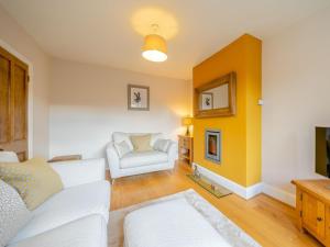 uma sala de estar com um sofá branco e uma parede amarela em Hare Bee Bee em Stratford-upon-Avon