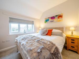 um quarto com uma cama grande e uma janela em Hare Bee Bee em Stratford-upon-Avon