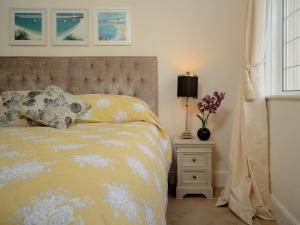 a bedroom with a bed and a table with a lamp at Kinbrae Apartment in Torquay