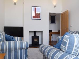 ein Wohnzimmer mit 2 blauen Sofas und einem Kamin in der Unterkunft Southfield in Steventon
