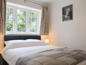 a bedroom with a large bed with two windows at Southfield in Steventon