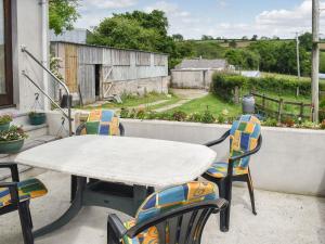 a table and chairs on a patio with a view at Dairy Cottage - Uk37833 in Pillaton