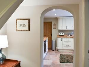 an archway leading into a kitchen with white cabinets at Arkle Terrace in Reeth