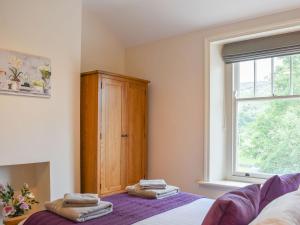 a bedroom with a bed and a wooden cabinet at Arkle Terrace in Reeth