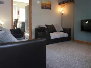 a living room with a couch and a tv at Nidd Cottage in Pateley Bridge