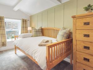 1 dormitorio con cama de madera y vestidor en The Coach House, en Kirkby Stephen