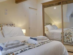 a room with two beds with towels and a mirror at The Coach House Halifax in Halifax