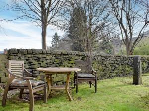 a table and two chairs and a stone wall at The Coach House Halifax in Halifax