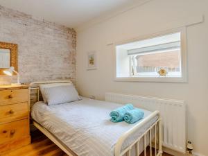 um pequeno quarto com uma cama e uma janela em Millers Cottage em Belford