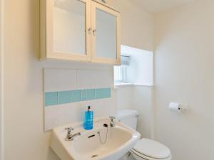 a white bathroom with a sink and a toilet at Millers Cottage in Belford