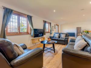 a living room with two leather couches and a tv at Bluebell Lodge-uk32958 in Molash