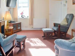 a living room with chairs and a couch and a tv at White Gables - Uk30688 in Portknockie