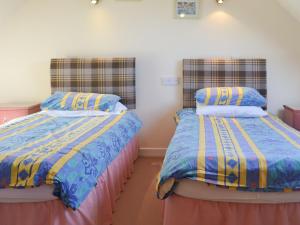 two beds sitting next to each other in a room at White Gables - Uk30688 in Portknockie