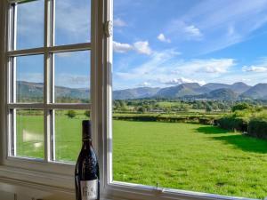 a bottle of wine sitting next to a window with a view at Skiddaw - Uk1354 in Applethwaite