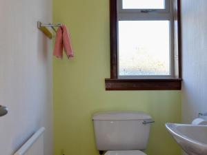 a bathroom with a toilet and a sink and a window at Wester Links in Fortrose