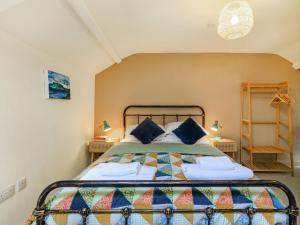 a bedroom with a bed with blue pillows at Coach House Retreat - Uk32202 in Burton Bradstock