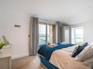 a bedroom with a large bed and a window at Hazelgrove Lodge Barn in Kelbrook