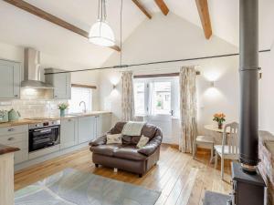 a living room with a leather chair and a kitchen at The Croft in Laneham