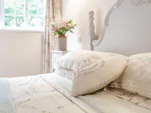 a bedroom with a white bed with pillows and a window at The Croft in Laneham