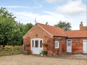 a brick cottage with white doors and a fence at The Croft in Laneham