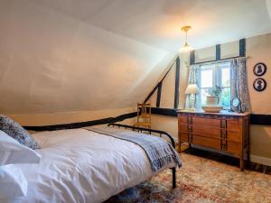 a bedroom with a bed and a dresser and a window at Little Crown in Winfarthing