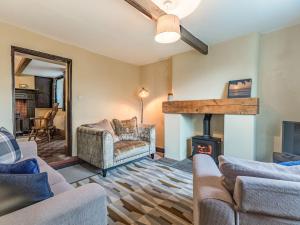 a living room with couches and a wood stove at Spring Cottage in Endon