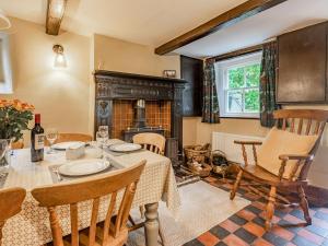 une salle à manger avec une table et une cheminée dans l'établissement Spring Cottage, à Endon