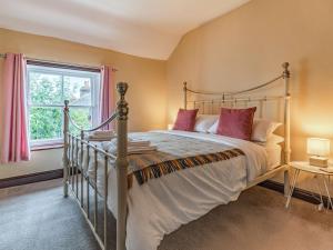 a bedroom with a large bed and a window at Spring Cottage in Endon