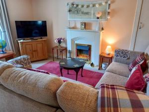 Tradewinds في Portknockie: غرفة معيشة مع أريكة ومدفأة