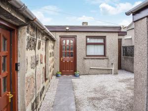 a brick house with a red door in a courtyard at Belger Cottage in Inverallochy