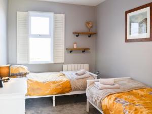 Un pat sau paturi într-o cameră la Broomlands Cottage